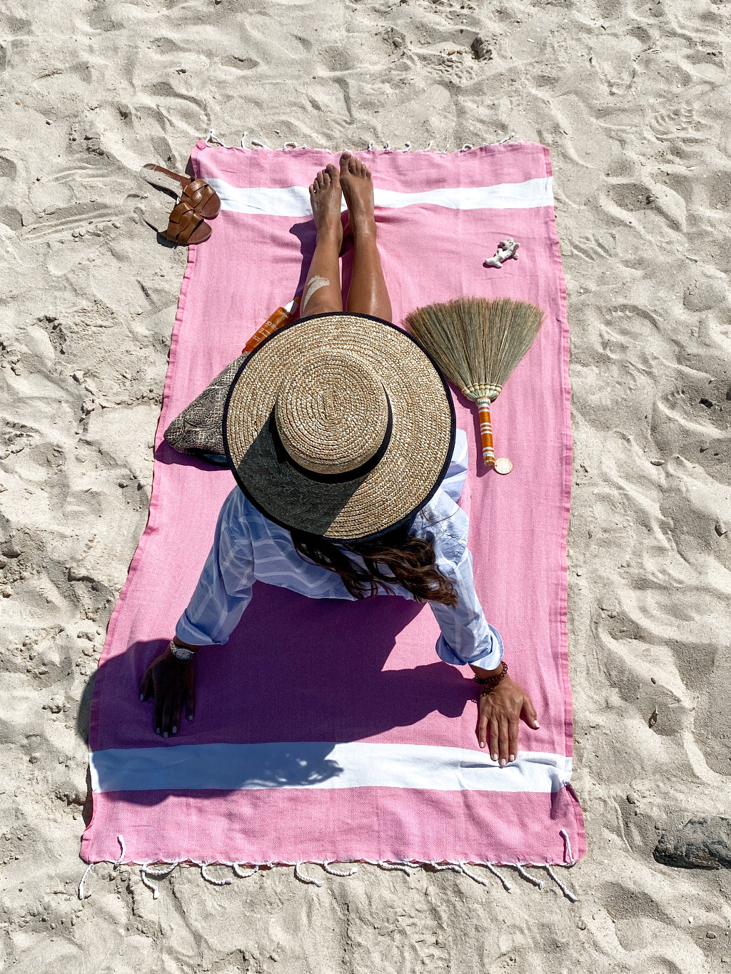 Serviette de plage légère en coton – Lifestyle plage - une femme est allongee sur la serviette - une brosse anti sable et de la creme solaire sont disposés sur la serviette – My Summer Fan

A person lying face down on a lightweight cotton beach towel – a sand repelling brush and a sunscreen tube are placed beside the towel – Beach lifestyle – My Summer Fan